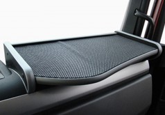 Grauer Beifahrertisch mit schwarzer, strukturierter Ablageflche im LKW-Innenraum.