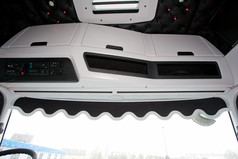 Schwarze Scheibenbordre mit heller Kunstlederkante und Wellenform im LKW-Fahrerhaus.