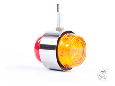 Kleines LED-Spiegellicht mit roter und gelber Linse und Chromrahmen.