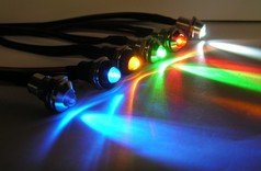 Reihe leuchtender LED-Schraubleuchten in Blau, Orange, Grn, Rot und Wei mit Metallgehuse.