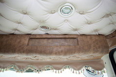 Braune Scheibenbordre mit Bommeln in Alkantara-Optik im LKW-Innenraum.