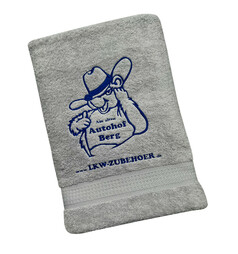 Graues Baumwoll-Duschtuch mit blauem Autohof Berg Stick und www.LKW-ZUBEHOER.de Schriftzug.