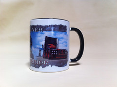Weie Tasse mit schwarzem Henkel und Rand, bedruckt mit einem dunklen LKW und den Texten "THE NEW WARRIOR" und "TRUCKS STOP HERE".