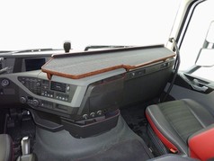 Durchgehender Tisch mit Holzrand und dunkler Oberflche im Volvo FH 4 Innenraum.