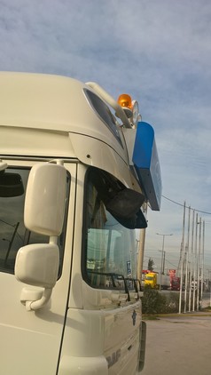 Montierte Edelstahl-Halterung fr Leuchtkasten auf dem Dach eines weien DAF LKW, mit blauem Leuchtkasten.