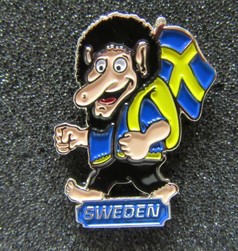 Scandi Pin: Lachender Troll mit schwarzem Haar, blauer Kleidung und gelbem Rucksack, der eine schwedische Flagge trgt. Text: SWEDEN.