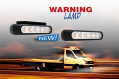 Ein orangefarbener LED-Blitzer mit schwarzem Gehuse, auf einem Abschleppwagen in Bewegung.