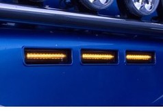 Leuchtende, rechteckige LEDSON Lampen fr Sonnenblende in Amberfarbe, an blauem LKW-Teil montiert.