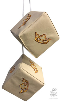 Beigefarbene Wrfel aus Kunstleder mit goldener Kronenstickerei, an einer Schnur hngend.