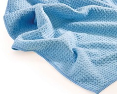 Ein hellblaues Waffeltuch mit sichtbarer Waffelstruktur und doppelt vernhtem Kantenschutz auf weiem Hintergrund.