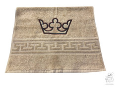 Taubes Duschtuch mit gestickter Krone und Mander-Muster.