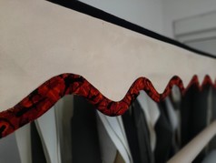 Scheibenbordre in Lederoptik, hell, mit roter, gemusterter Plschkante. Zeigt doppelt genhten Stoff.