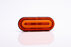 Ovale, orange Begrenzungsleuchte mit Reflexionsflche und schwarzem Rahmen auf weiem Hintergrund.