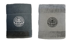 Baumwollhandtcher in Grau und Schwarz, gefaltet, mit "100% TRUCKER old school" Stickerei und Totenkopf-Motiv.