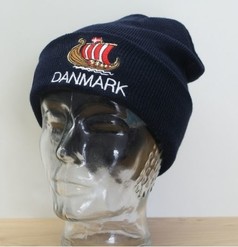 Dunkelblaue Strickmtze mit gesticktem Schiffsmotiv und dem Schriftzug 