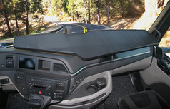 Groe, schwarze Ablage mit strukturierter Oberflche und Ausschnitt auf dem Armaturenbrett eines MAN TGX LKW.