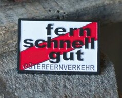 Ein rechteckiger Scandi Pin mit weiem Grund, rotem Streifen und dem Text 