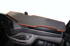 Groe LKW-Armaturenbrett-Ablage in Carbon-Optik mit braunem Holzrand.