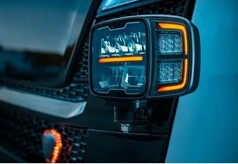 Schwarzer Fernscheinwerfer "HI-LO" mit klarer Linse und leuchtendem orangefarbenem Positionslicht, montiert an einem LKW.