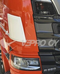 Weier Windabweiser aus Kunststoff am orangefarbenen Scania LKW, neben dem schwarzen Khlergrill und Scheinwerfer.