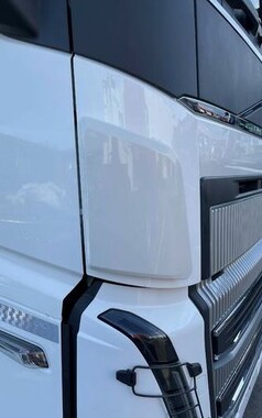 Weier Windabweiser aus glnzendem Kunststoff, montiert an der Front eines weien LKWs neben dem Khlergrill.