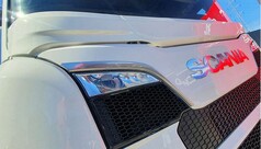 Weie Scheibenblende auf einem Scania LKW. Frontansicht mit Scania Logo und Scheinwerfern.