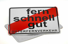 Weies Schild mit diagonalem roten Streifen und schwarzem Text "fern schnell gut" und "GTERFERNVERKEHR".