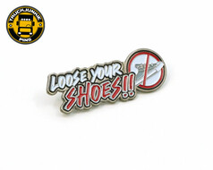 Metallpin mit wei-rotem Schriftzug "LOOSE YOUR SHOES!!" und einem Verbotsschild fr Schuhe.
