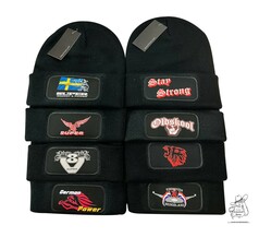 Mehrere schwarze Wintermtzen mit farbigen Drucken im Patchfeld, darunter 