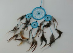 Blauer Traumfnger mit mehreren Ringen, verziert mit braunen Federn und dunklen Perlen.