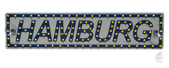 Beleuchtetes Namensschild mit Schriftzug HAMBURG, gelben LEDs am Rand und in den Buchstaben, inklusive Saugern.
