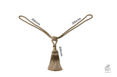 Goldfarbene Kordel mit Quaste aus geflochtenem Material auf weiem Hintergrund.