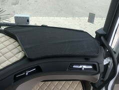 Schwarzer Beifahrertisch mit strukturierter Oberflche, im Innenraum eines DAF-LKWs ber beiger Polsterung montiert.