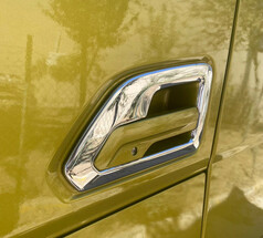 Glnzender Edelstahl-Trgriffrahmen auf einer gelb-grnen LKW-Tr.