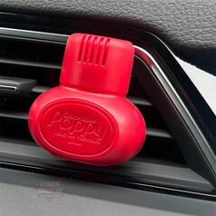 Roter Poppy Grace Mate Auto-Lufterfrischer auf einem Lftungsgitter im Fahrzeug.
