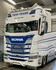Frontansicht eines weien Scania New Generation LKWs mit blauem Khlergrill und montiertem weiem Numberplate Anbauteil mit LEDs.