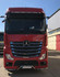 Silberne Eckrohre mit LEDs, montiert an der Front eines roten Mercedes-Benz Actros LKW.