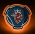 Beleuchtetes Scania Emblem mit orangefarbener LED-Kontur auf dunklem Hintergrund.