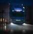 Blauer Scania LKW mit leuchtendem Ledson Flexistrip Arc LED-Streifen in Xenon-Wei am Khlergrill, nachts auf nassem Asphalt.