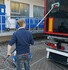 Mann reinigt schwarzen LKW mit einer Vikan LKW Waschbrste (grn/rot) und Teleskop-Stiel, erzeugt Schaum.